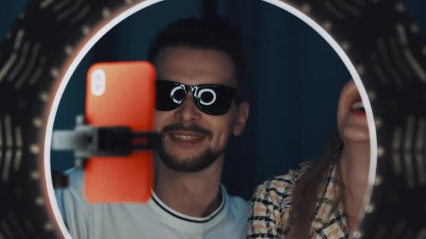 Felnőtt férfi napszemüvegben és nő szépség blogger beszélni előtt gyűrű fény - Felvétel, videó