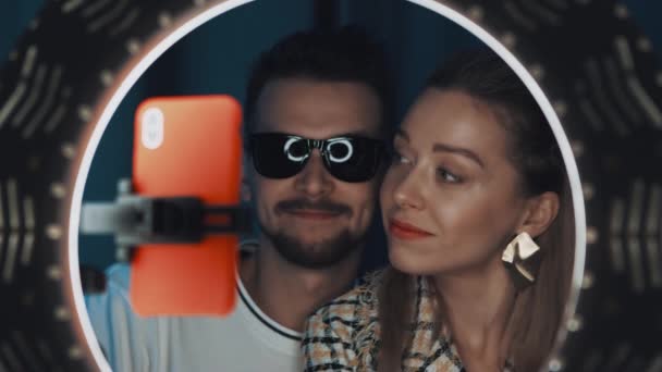 man in zonnebril en vrouw schoonheid blogger praten en glimlachen in de voorkant van ring licht - Video