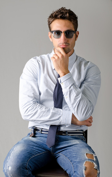 Handsome young man wearing shirt, necktie and ripped jeans - Zdjęcie, obraz