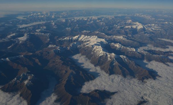 Widok z lotu ptaka nad chmurami na szczytach gór - Zdjęcie, obraz