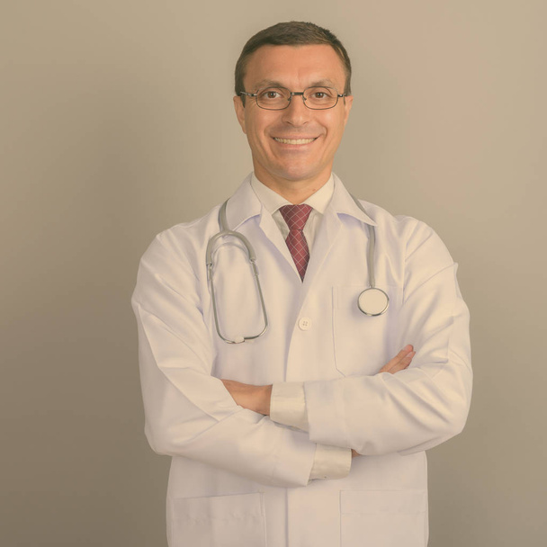 Studio shot of man doctor wearing eyeglasses against gray background - Foto, afbeelding