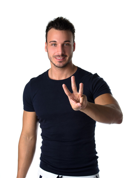 Handsome young man counting to three with fingers and hands - Photo, Image