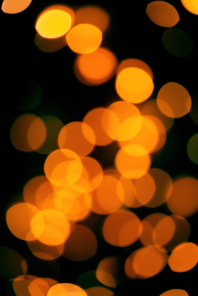Black background with bright warm bokeh lights. Holiday, Christmas and New Year background. Ideal to layer with any design - Photo, Image