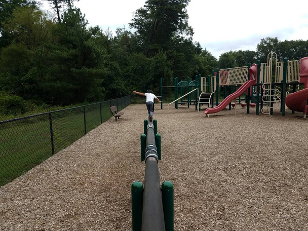 bambino ragazzo sul fascio di equilibrio sul parco giochi
 - Foto, immagini