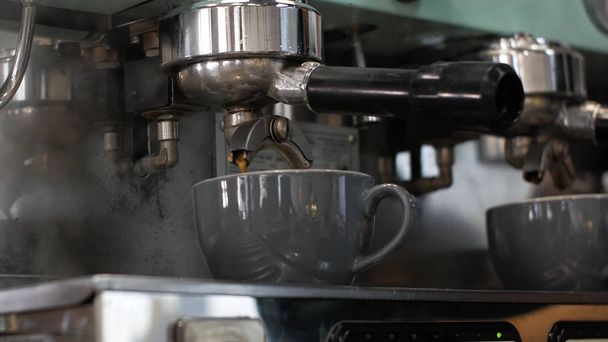Бариста на работе. Процесс приготовления кофе и какао. Стакан пенящегося молока. Электрические дрожжи кофейные бобы в фильтродержателе
. - Фото, изображение