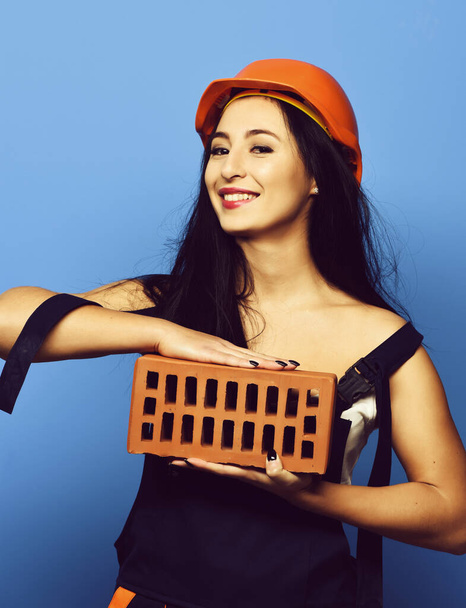 pretty cute sexy builder girl or smiling brunette woman in uniform - Photo, Image