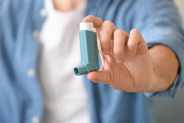Kranker Mann mit Asthma-Inhalator zu Hause, Nahaufnahme - Foto, Bild