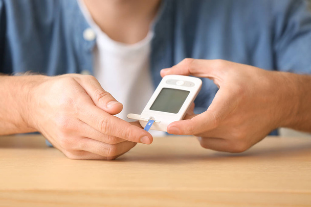 Diabeettinen mies tarkistaa verensokeri pöydässä, lähikuva
 - Valokuva, kuva