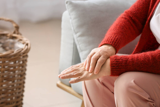 Seniorin leidet zu Hause unter Schmerzen im Handgelenk - Foto, Bild