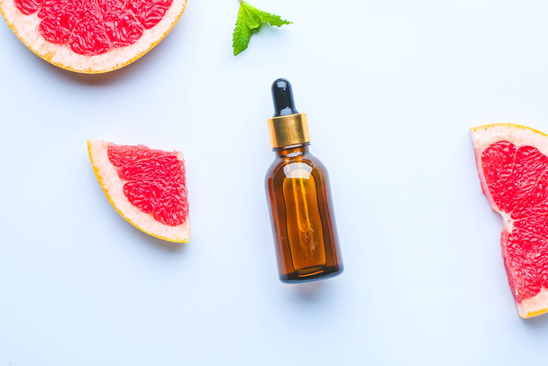 Flasche Grapefruit ätherisches Öl auf hellem Hintergrund - Foto, Bild