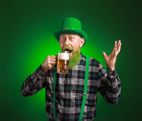Funny mature man with glass of beer on dark background. St. Patrick's Day celebration - Foto, imagen