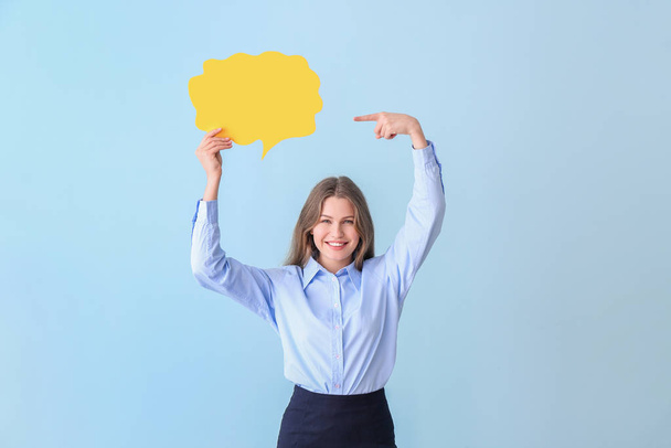 Young businesswoman with blank speech bubble on color background - Foto, Imagen
