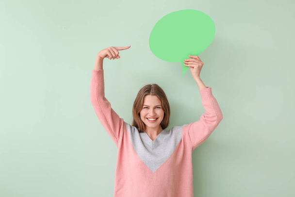 Young woman with blank speech bubble on color background - Фото, изображение