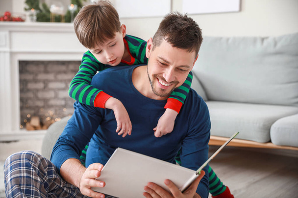 Маленький мальчик с отцом читает книгу дома
 - Фото, изображение