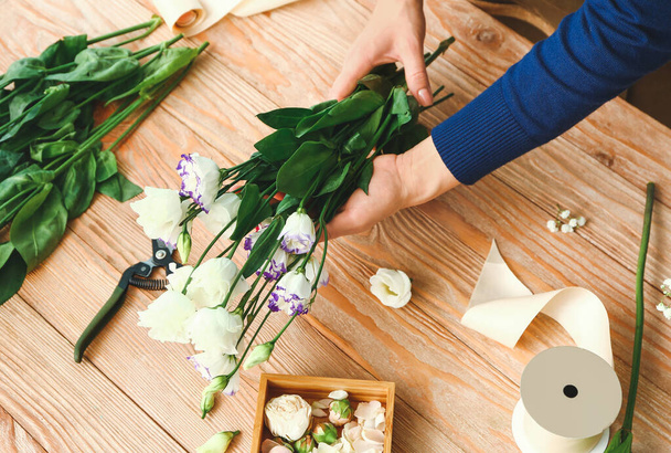 Femmina fiorista rendendo bellissimo bouquet a tavola
 - Foto, immagini