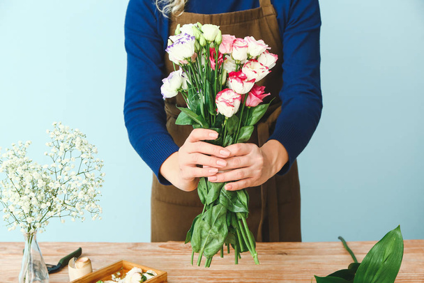 Female florist making beautiful bouquet at table - Foto, imagen