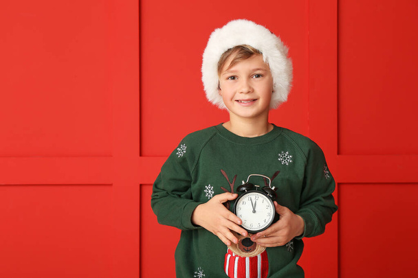 Little boy with alarm clock on color background. Christmas countdown concept - Photo, Image