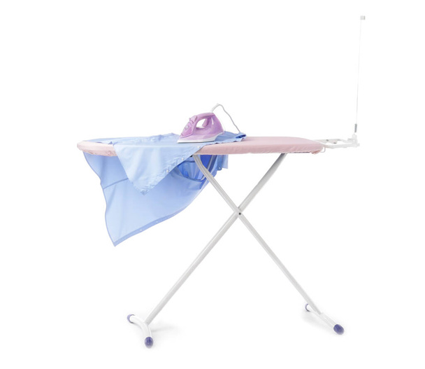Iron and clean clothes on board against white background - Photo, Image