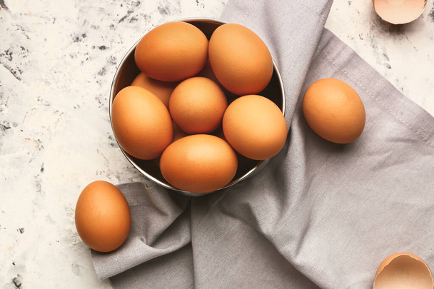 Bowl with fresh eggs on light background - Foto, imagen