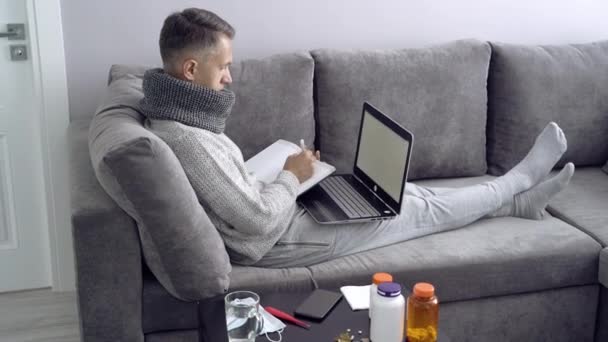Young man working from home during illness. Online education. - Imágenes, Vídeo