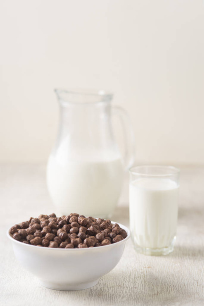 Завтрак: шоколадные шарики, свежее коровье молоко, избирательный фокус - Фото, изображение