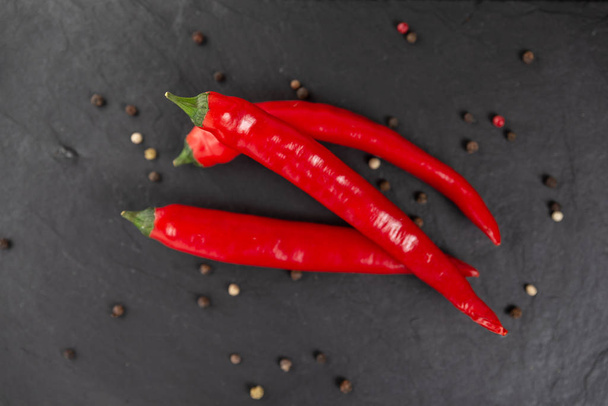 red chili peppers on a black chopping Board - Φωτογραφία, εικόνα