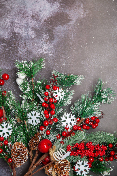 Christmas fir twigs with red berries and snowflakes on dark background - Фото, зображення