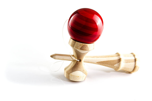 Кендама японская деревянная игрушка на изолированном белом. Деревянная игрушка с красным балом
. - Фото, изображение