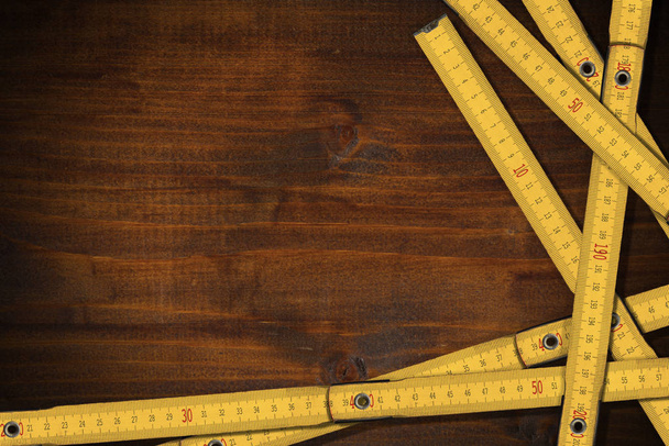 Желтые складные деревянные линейки на рабочем столе с копировальным пространством
 - Фото, изображение