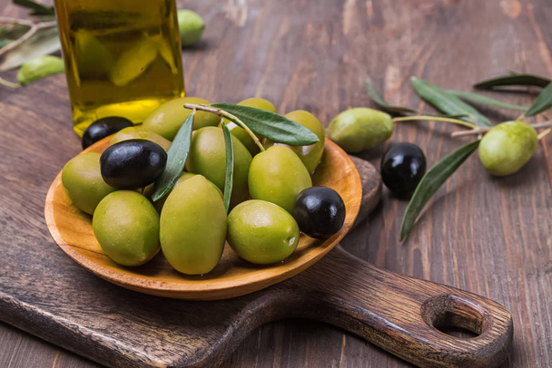 Green and black olives in small wooden plate - Φωτογραφία, εικόνα
