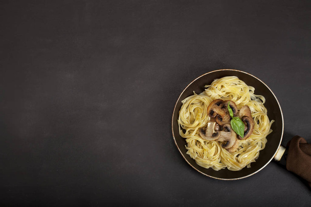 Tagliatelle pasta with fresh mushrooms on black background - Φωτογραφία, εικόνα