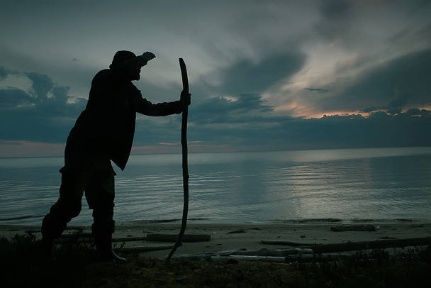 traveler with a stick walking along the lake at night - Fotoğraf, Görsel