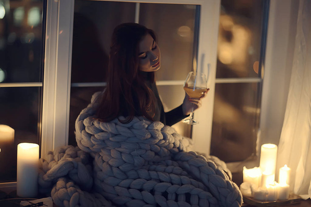 girl sitting in a blanket at the window, candles night, loneliness, young lonely girl, stress - Foto, immagini
