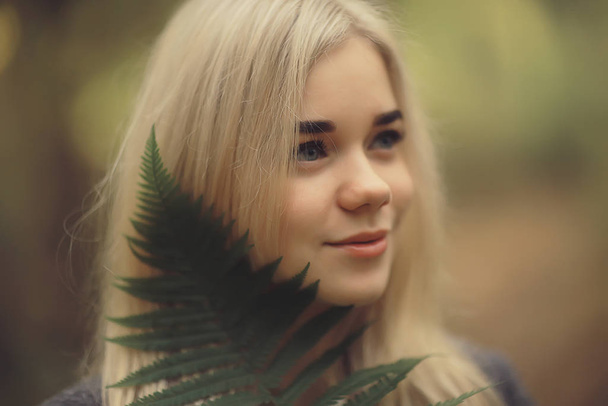 eco concept girl portrait fern, young adult model blonde, green leaf on face - Fotó, kép