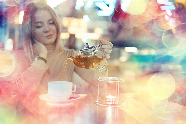young model drinks tea in a cafe, vacation concept table setting - Photo, image