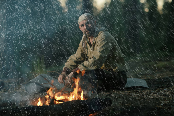 Jäger am Lagerfeuer, ein Mann in der Taiga, der sich im Feuer sonnt - Foto, Bild