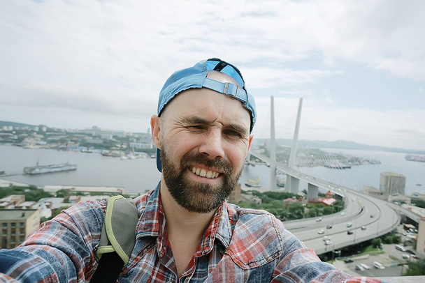 Vladivostok man bridge portrait, a man in a tourist cap in Russia - Foto, Imagen