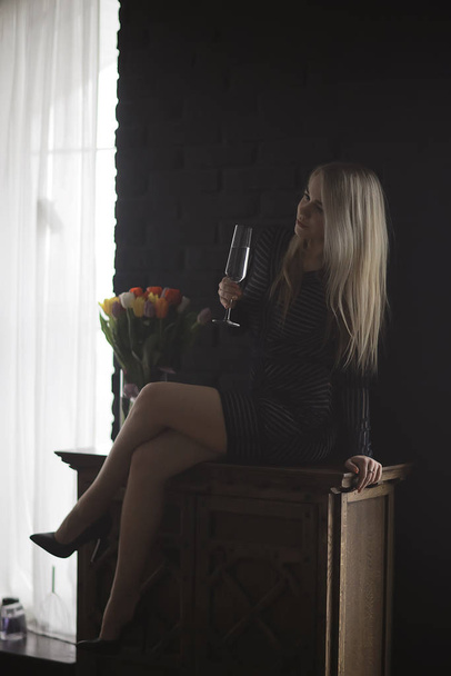 sexy blonde girl drinks champagne from a glass, evening glamorous style portrait - 写真・画像