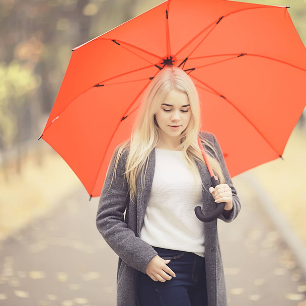 girl with umbrella posing in autumn park, october landscape lonely woman holding a red umbrella - Foto, Imagem