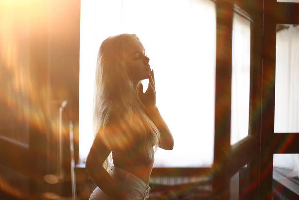 sexy model in a loft home interior, back light silhouette rays of the sun evening - Photo, Image