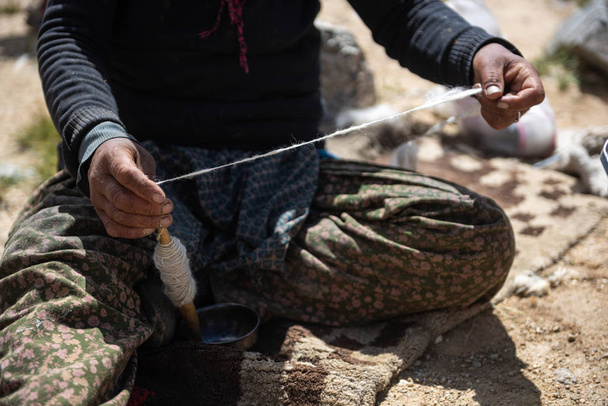 Mani di una donna filatura di fibre di lana
 - Foto, immagini