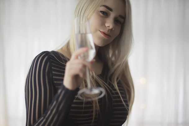 sexy blonde girl drinks champagne from a glass, evening glamorous style portrait - 写真・画像