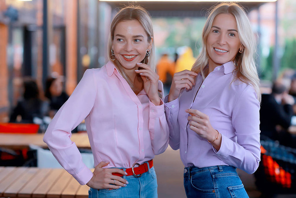 two girlfriends in pink shirts, young adult beautiful models in shirts, casual style - Фото, зображення