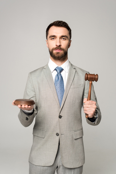 confident judge holding gavel while looking at camera isolated on grey - Photo, Image