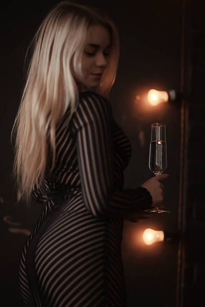 sexy blonde girl drinks champagne from a glass, evening glamorous style portrait - Foto, imagen