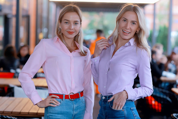 two girlfriends in pink shirts, young adult beautiful models in shirts, casual style - Foto, Bild