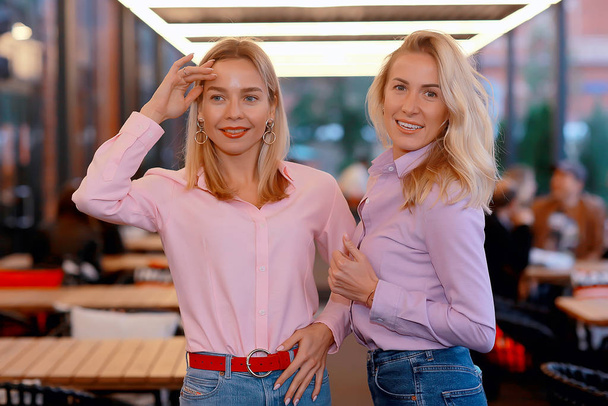 two girlfriends in pink shirts, young adult beautiful models in shirts, casual style - Fotoğraf, Görsel