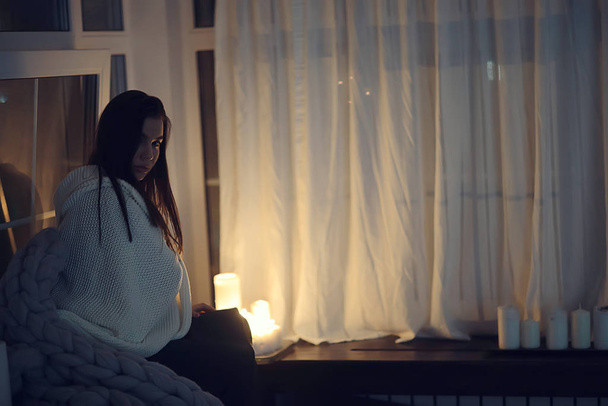 girl sitting in a blanket at the window, candles night, loneliness, young lonely girl, stress - Fotó, kép