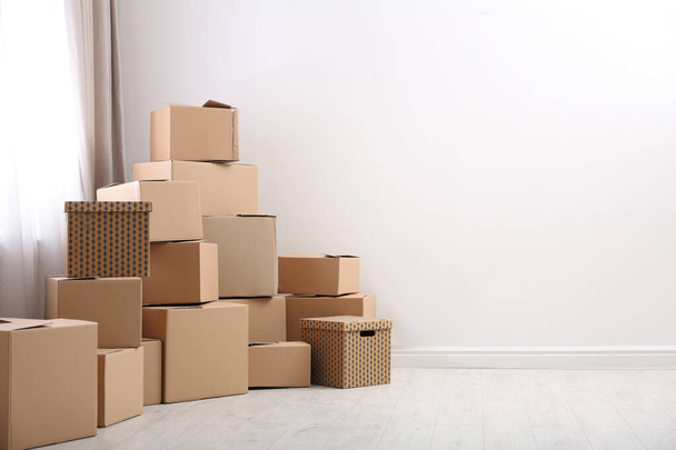 Pile of moving boxes in empty room, space for text - Foto, Imagem