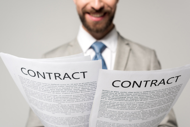 cropped view of smiling businessman reding contracts isolated on grey - Photo, Image